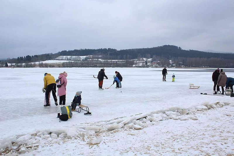 U Horní Plané se na zamrzlém Lipně vesele bruslí. Sem tam tudy ale na druhý břeh přejede i auto. Jen o pár set metrů dál přitom stále jezdí přívoz.
