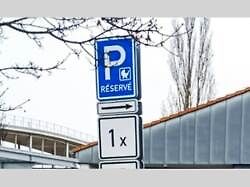 Značka s vyhrazeným místem pro parkování rodiny s dětmi, přepravující malé dítě v kočárku.