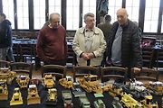 Návštěvníci diskutují v Miroslavem Buřtem nad jeho papírovými modely buldozerů.