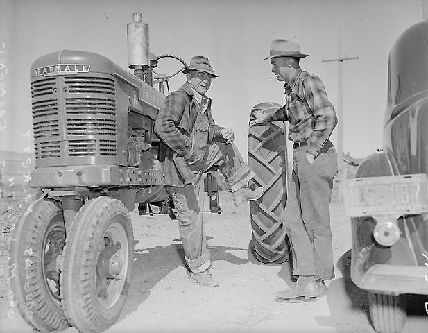 Američtí farmáři diskutující u traktoru Farmall H., zdroj: Wikimedia Commons, Clem Albers - U.S. National Archives and Reco, volné dílo