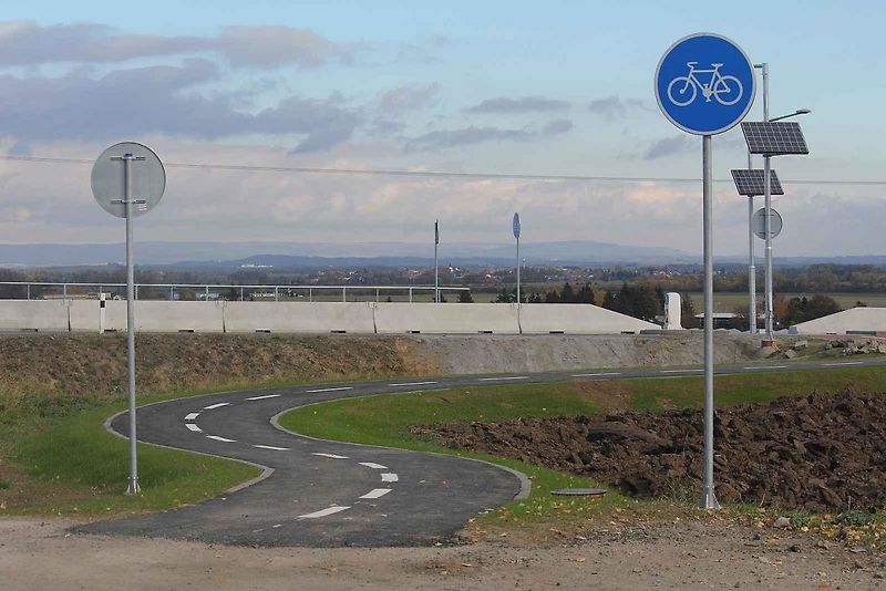 Červené cyklopruhy v ulici SNP v Mostě. Do vyhrazeného jízdního pruhu pro cyklisty mohou vjíždět motorová vozidla jen v zákonem stanovených výjimkách.