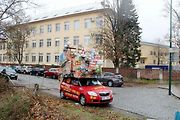 Auto se spoustou dárků na střeše budí rozruch vedle kruhového objezdu u nemocnice.