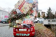 Auto se spoustou dárků na střeše budí rozruch vedle kruhového objezdu u nemocnice.