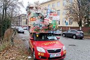 Auto se spoustou dárků na střeše budí rozruch vedle kruhového objezdu u nemocnice.