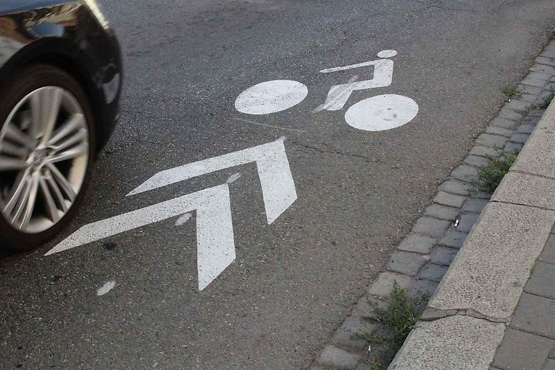Červené cyklopruhy v ulici SNP v Mostě. Do vyhrazeného jízdního pruhu pro cyklisty mohou vjíždět motorová vozidla jen v zákonem stanovených výjimkách.