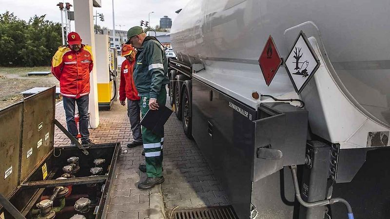 Venkovní prodejce pomáhá lidem s tankováním a současně je informuje o přednostech prémiovějších typů paliv