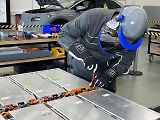 Povšimněte si ochranného obleku. Ten musí mít technik pokaždé, když pracuje s otevřenou vysokonapěťovou baterií