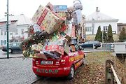 Auto se spoustou dárků na střeše budí rozruch vedle kruhového objezdu u nemocnice.