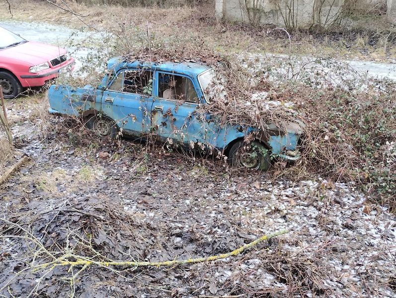 Dlouhodobě odstavené starší auto s poškozenou karoserií u cesty v Libčicích.- Automatické vyřazení má mířit na auta bez platné technické i pojištění po dobu delší než pět let. Samotné stáří vozu nerozhoduje. Ilustrační foto.