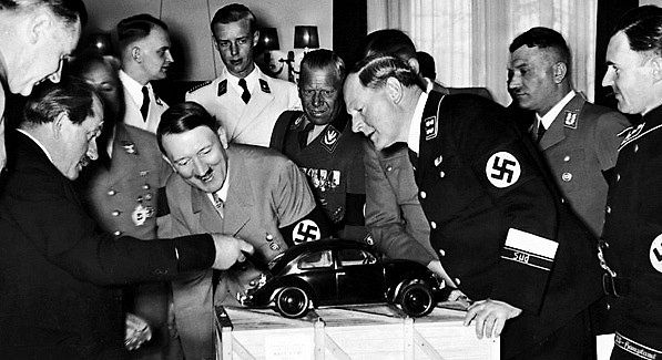 Ferdinand Porsche ukazuje Adolfu Hitlerovi model lidového vozu. 