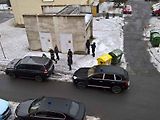 Porsche Cayenne - auto s modrým majákem na snímku u žluté popelnice.