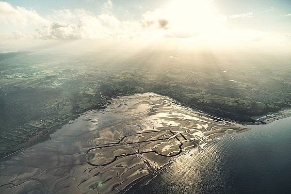 Na pláži Red Wharf Bay v Anglesey vytvořilo šestLand Roverů kilometrovou kresbu v písku.
