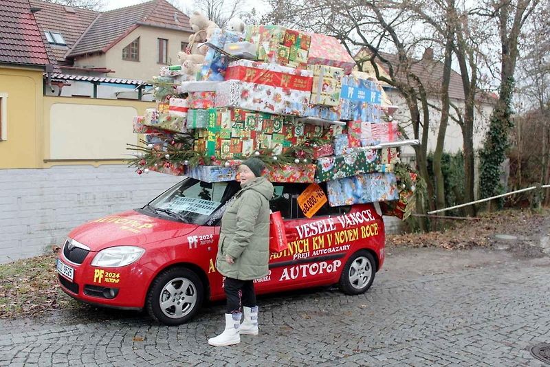 Auto se spoustou dárků na střeše budí rozruch vedle kruhového objezdu u nemocnice.