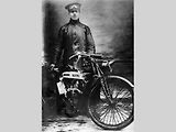 Voják George Kimber v období I. světové války pózuje s motocyklem Douglas.
