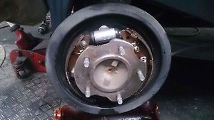 Odkrytá bubnová brzda ukazuje čelisti, pružiny i mechanismus ukrytý za brzdovým bubnem.