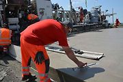 Pokládka betonové vrstvy vozovky je milníkem stavby dálnice D1 na úseku Říkovice - Přerov. Stavebníci ji zahájili tento týden.
