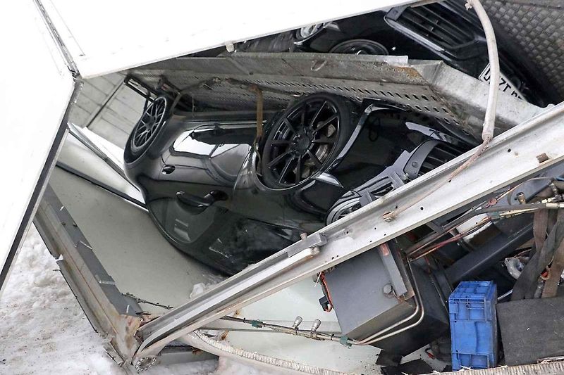 Převrácený přívěs vezoucí nové Porsche.