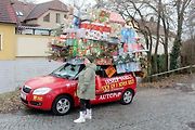 Auto se spoustou dárků na střeše budí rozruch vedle kruhového objezdu u nemocnice.