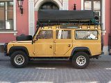 Vůz Land Rover Defender 110 Station Wagon Td5. Stejný model, vyrobený v roce 2003, si zahrál v seriálu Smrt v ráji, kde představoval policejní vozidlo.