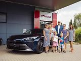 Vítězka soutěže s rodinou si přebírá cenu v pražském sídle Toyoty.