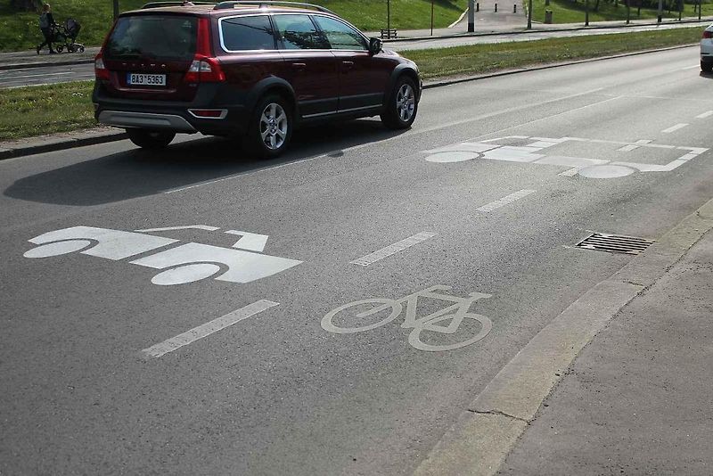 Červené cyklopruhy v ulici SNP v Mostě. Do vyhrazeného jízdního pruhu pro cyklisty mohou vjíždět motorová vozidla jen v zákonem stanovených výjimkách.