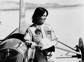 Kitty O’Neil, do roku 2019 nejrychlejší žena světa právě pózuje u raketového vozidla SMI Motivator, se kterým vytvořila ženský pozemní rychlostní rekord.