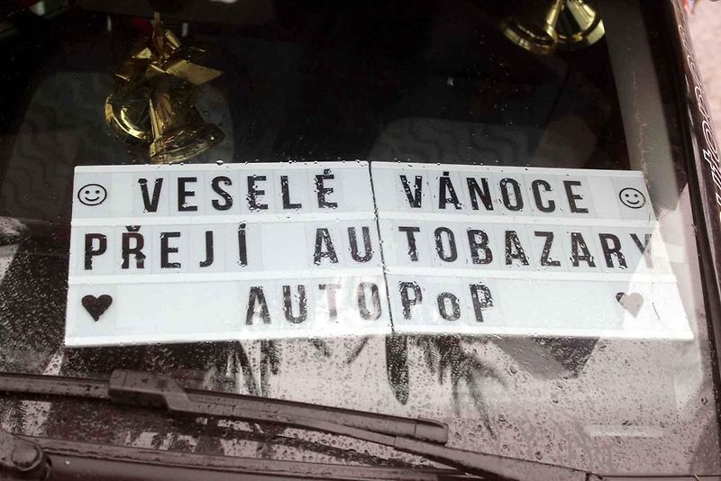 Auto se spoustou dárků na střeše budí rozruch vedle kruhového objezdu u nemocnice.