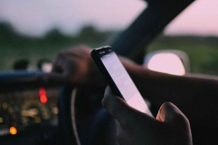 Psaní zpáv na mobilu v autě. Ilustrační foto